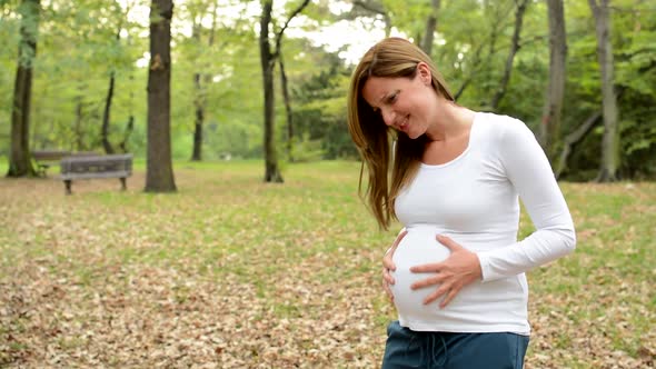 Young Pretty Pregnant Woman Has Abdominal Pain in Park