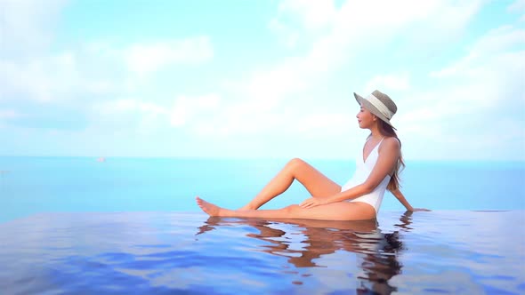 Young asian woman enjoy around outdoor swimming pool for leisure