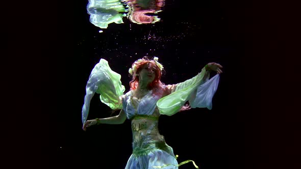 Female Figure Underwater in Darkness, Woman Is Keeping Afloat and Moving Hands, Slow Motion