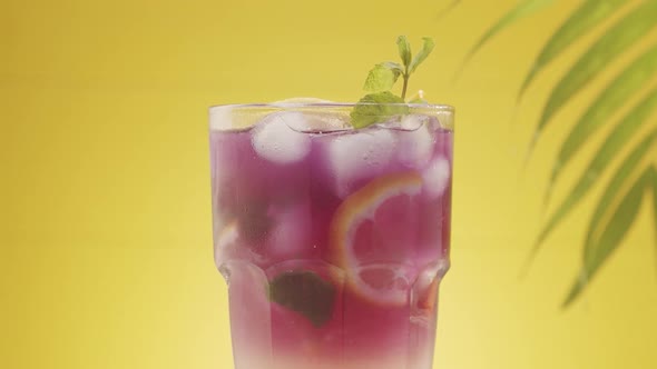 Glass of Refreshing Summer Lemonade Cocktail with Ice and Lime and Mint Rotating