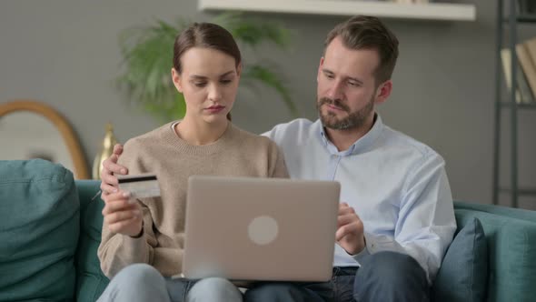 Couple Having Successful Online Shopping on Laptop on Sofa