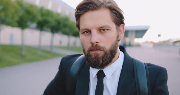 Bearded Office Manager with Backpack which Posing on Camera on the Street Near Big Urban Building