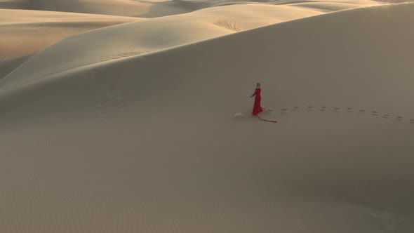  Distant Drone View of a Woman Walking By Sand Dunes at the Desert Nature, USA