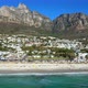 Wide side tracking shot showcasing the entire length of Camps Bay beach - VideoHive Item for Sale