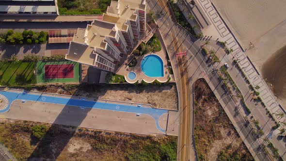 high rise building with modern architecture and sports area in front of the beach. Bird eyes view