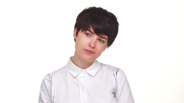 Thoughtful Young Woman Calmly Looking Around Smiling at Camera Isolated Over White Background in