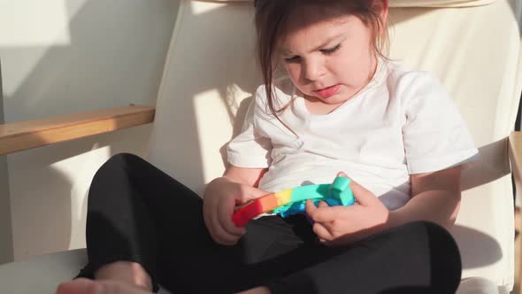 Toddler Girl with Popit Toy in Rainbow Colours