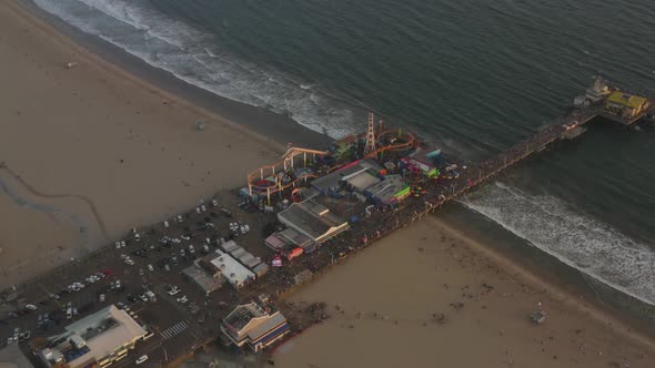 AERIAL: Circling Santa Monica Pier, Los Angeles From Above at Beautiful Sunset with Tourists