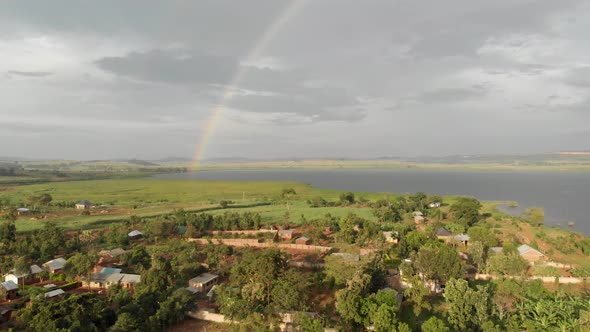 Aerial shot of rural villages with a rainbow in the background in Africa.