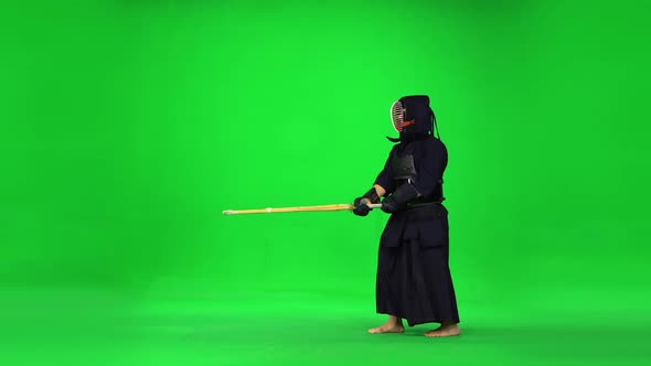 Masculine Kendo Warrior Practicing Martial Art with the Bamboo Bokken on Green Screen.