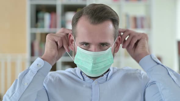 Portrait of Young Man Demonstrating Wearing Mask 