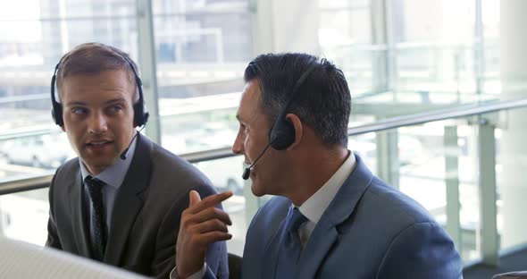 Businessmen wearing headsets in a modern office