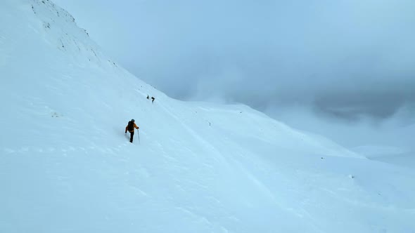 Mountaineer Walking Through Deep Snow During Ascent on a Mountain