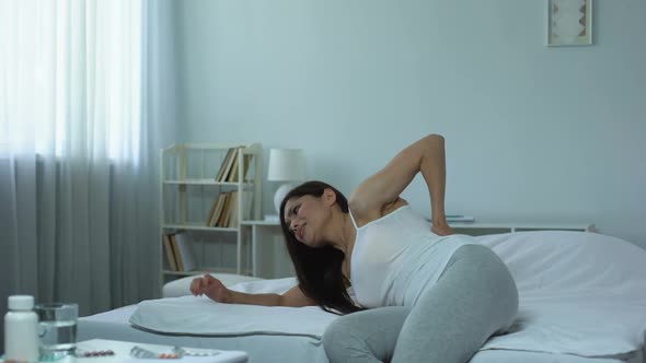 Female Suffering Severe Back Pain While Lying in Bed, Consequences of Injury