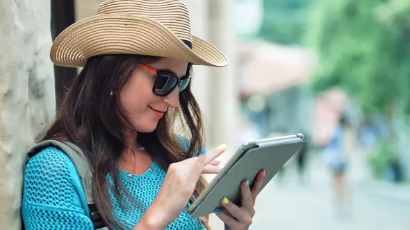 Portrait of Beautiful Lost Female Tourist Standing Using Tablet PC in Summer European City