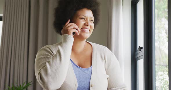 Video of happy plus size african american woman using smartphone