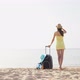 Beautiful Woman in a Hat with Suitcase Against the Sea During Summer Travel Vacation - VideoHive Item for Sale