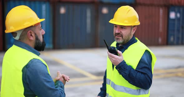 Engineer men controlling shipping containers inside industrial port