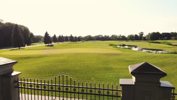 Huge Green Golf Field Behind Steel Park Fence