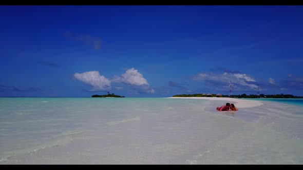 Romantic couple relax on beautiful shore beach voyage by aqua blue ocean with white sandy background