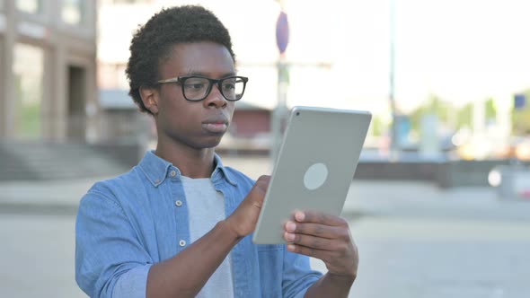 Portrait of Young African Man Using Digital Tablet Outdoor