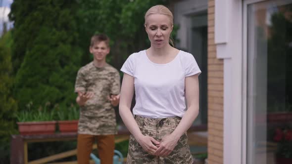 Stressed Military Mother Looking at Camera As Angry Teenage Son Shouting Gesturing in Slow Motion at