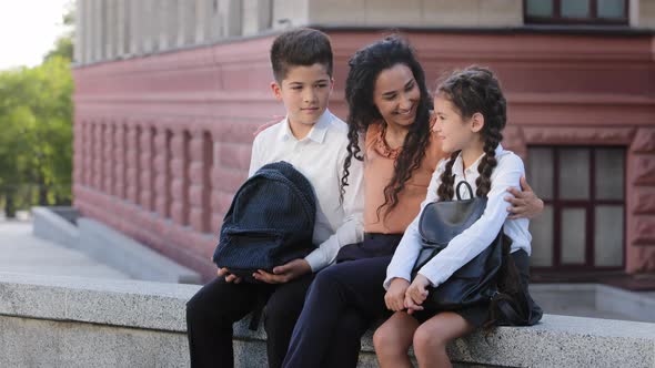 Hispanic Family Woman Mother Mommy Teacher Sitting Outdoors on Background of School Building with