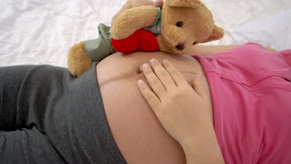 Happy Pregnant Woman Sleeping on Bed in Bedroom