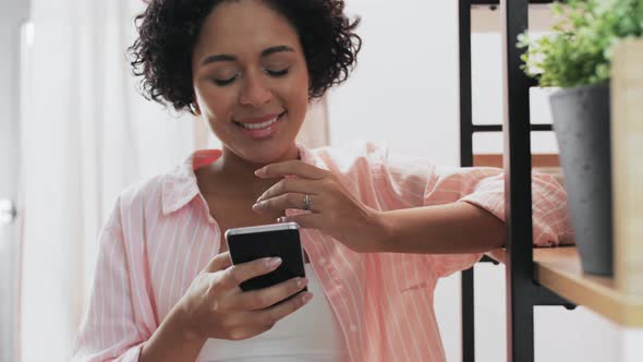 Smiling Woman with Smartphone at Home