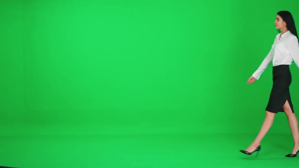 Young Businesswoman in a Suit Walks on a Green Background Chroma Key Template