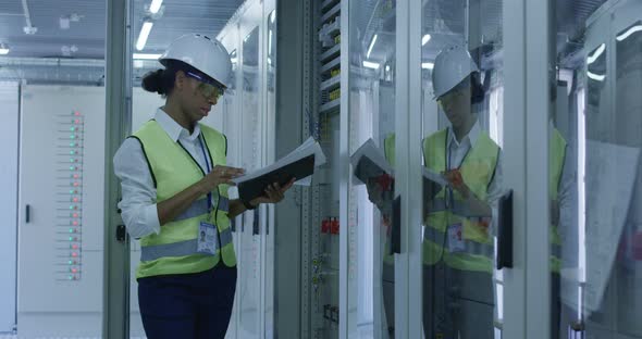 Female Electrical Worker Reading Paperwork