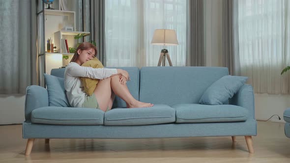 Unhappy Lonely Depressed Young Asian Woman At Home, She Is Sitting On The Couch, Depression Concept