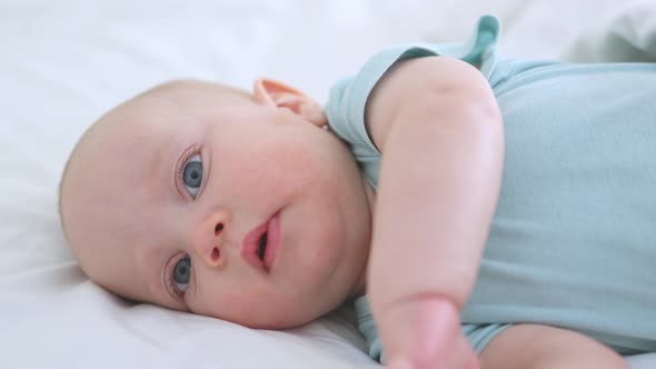 Beautiful Baby Lying in Bed Looking to Camera Happy Infant Bedroom Sunny Day