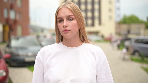 Portrait of a young sad woman on the background of the city. Close-up