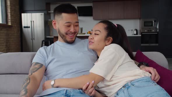 Portrait of Happy Asian Married Couple Relaxing on Couch