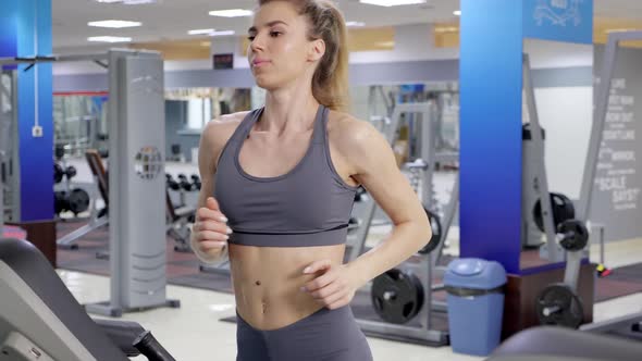 Young sporty Woman On Running Machine In Gym