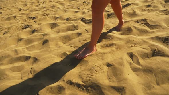 Slow Motion Shot of Woman’s Legs Walking Barefeet in Hot Sand