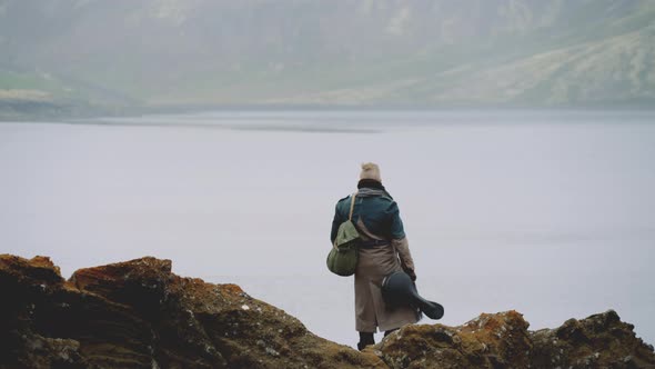 Travelling Man With Guitar On Rock In Icelandic Landscape