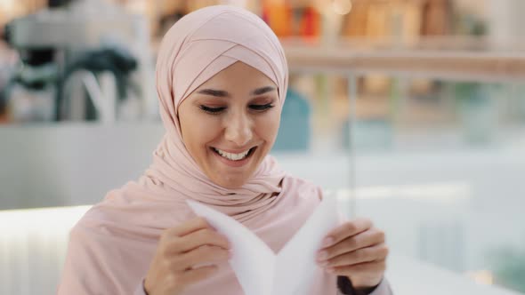 Closeup Young Excited Happy Arab Woman in Hijab Receiving Letter Reading Good Incredible News