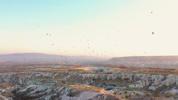 Hot Air Balloons Flying Over Rock Landscape at Cappadocia