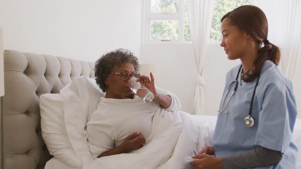 Mixed race woman being visited at home by a nurse. Social distancing and self isolation in quarantin