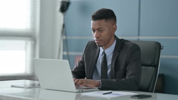 African Businessman Working on Laptop in Office