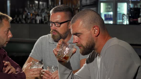 Handsome Man Looking To the Camera with Confidence While Drinking Whiskey