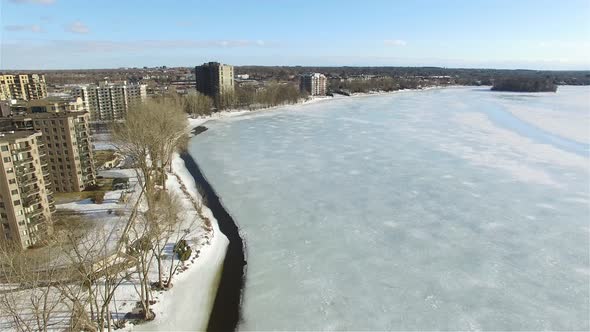 Drone view of a residential neighborhood of apartments near a frozen lake in Canada.