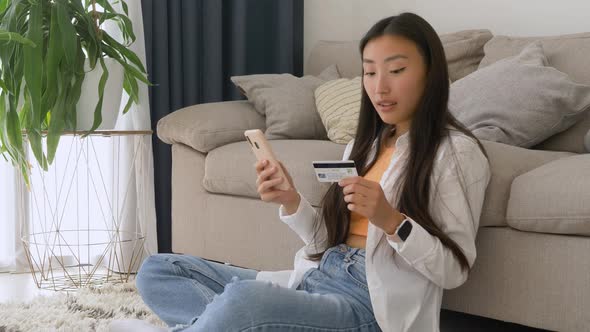 happy asian woman buying online with a smart phone