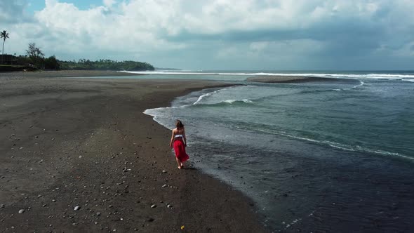 Young Woman Walking on Black Sand Beach