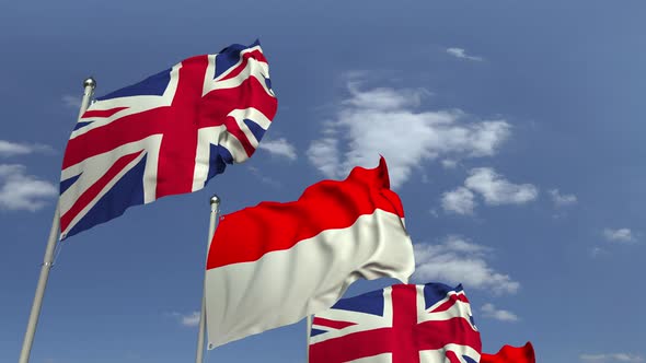 Flags of Indonesia and the United Kingdom Against Blue Sky