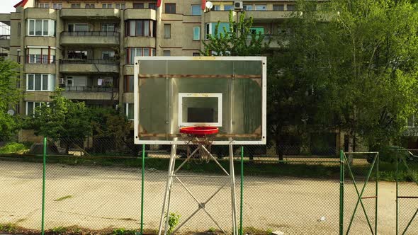 Backward Aerial Footage of Empty Basketball Field in the Neighborhood