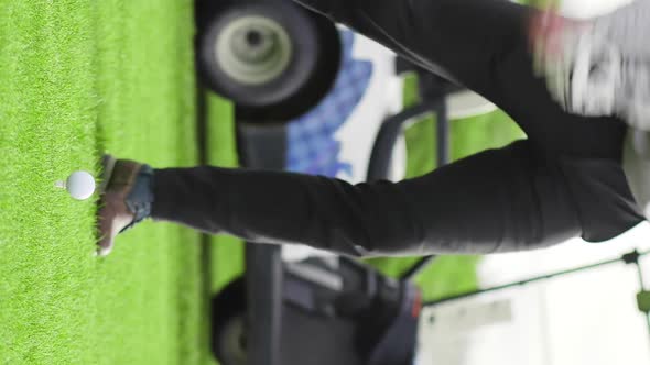 Vertical Close Up of Sportsman Hitting Golf Ball with Club