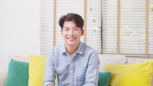 Asian handsome man looking at camera smile at home